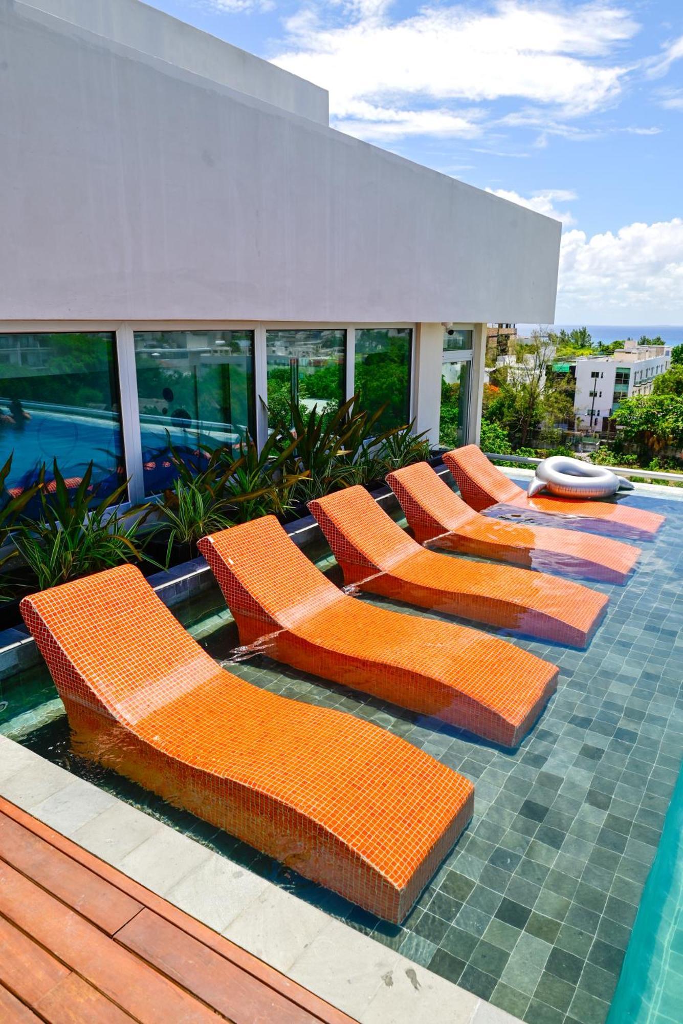 Aloft Playa Del Carmen Hotel Exterior photo Sunbathing chairs at a pool